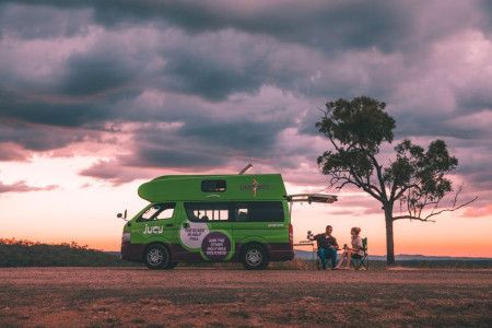A couple sitting outside their campervan. 