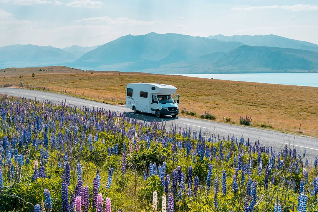 Mum, dad and child inside a car all smiling and gazing upon each other while staring at the daylight sun through their car windows.