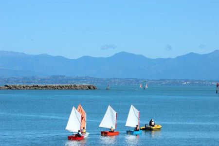 People sailing in colourful boats in Nelson. 
